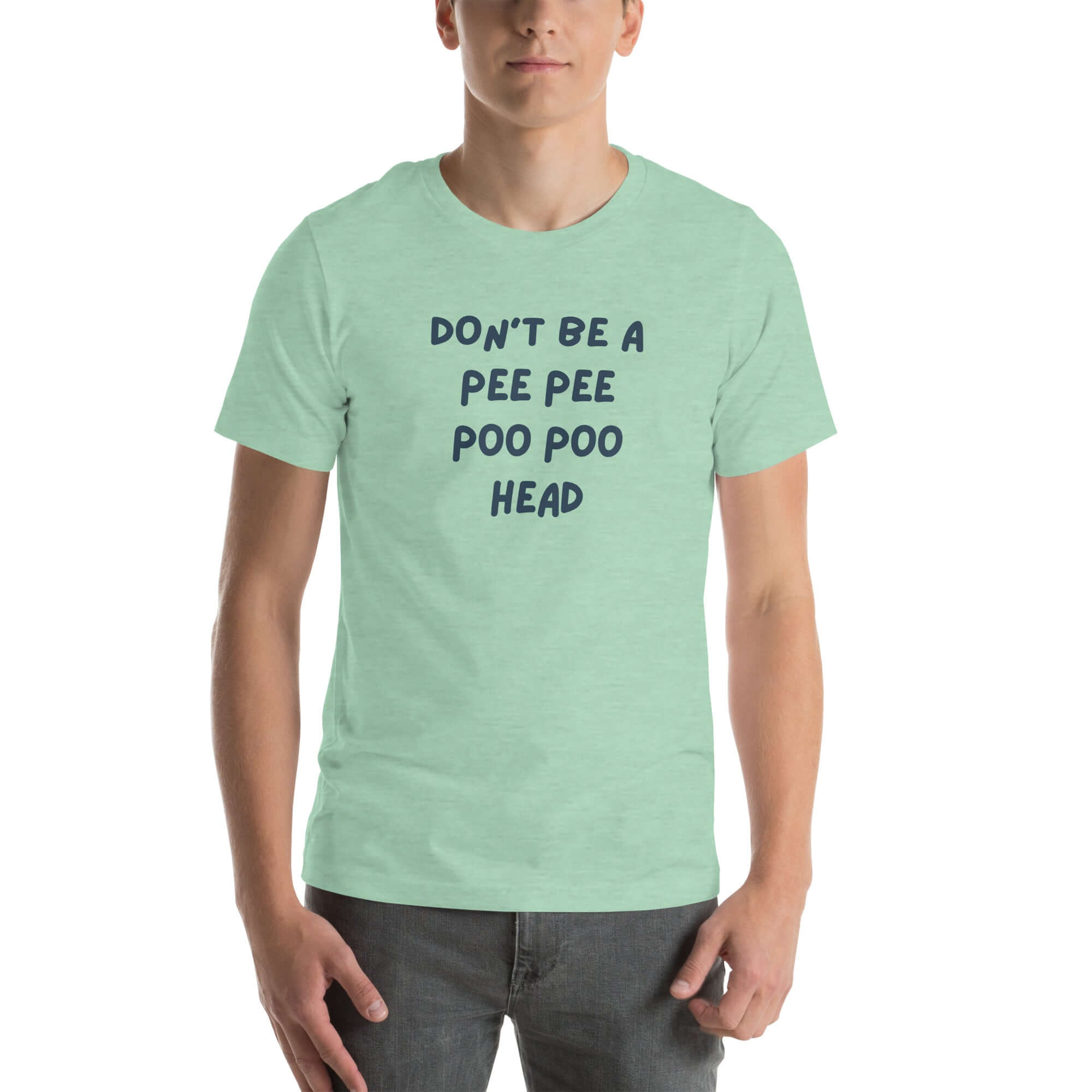 Man wearing mint “DON’T BE A PEE PEE POO POO HEAD” t-shirt, standing casually with hands by pockets.