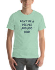 Man wearing mint “DON’T BE A PEE PEE POO POO HEAD” t-shirt, standing casually with hands by pockets.