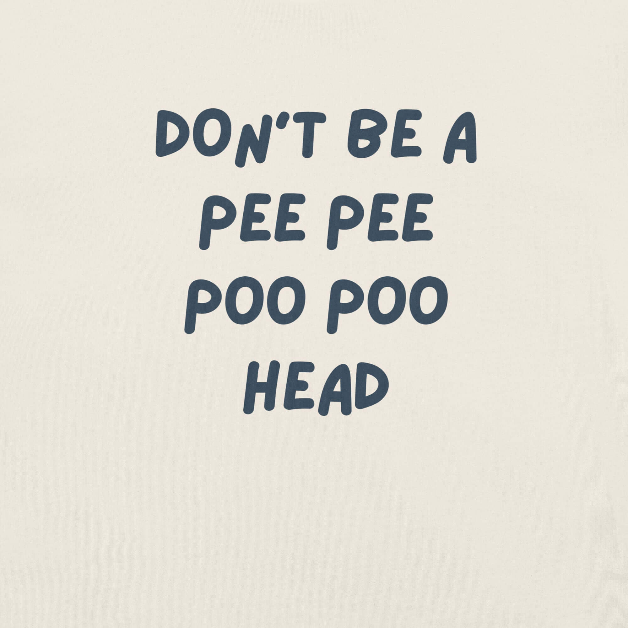 Man wearing white “DON’T BE A PEE PEE POO POO HEAD” t-shirt, standing casually with hands by pockets.