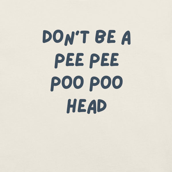 Man wearing white “DON’T BE A PEE PEE POO POO HEAD” t-shirt, standing casually with hands by pockets.