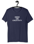 Navy t-shirt on a hanger with the phrase “HIGH ON CREATIVITY” printed in white, centered on the chest.