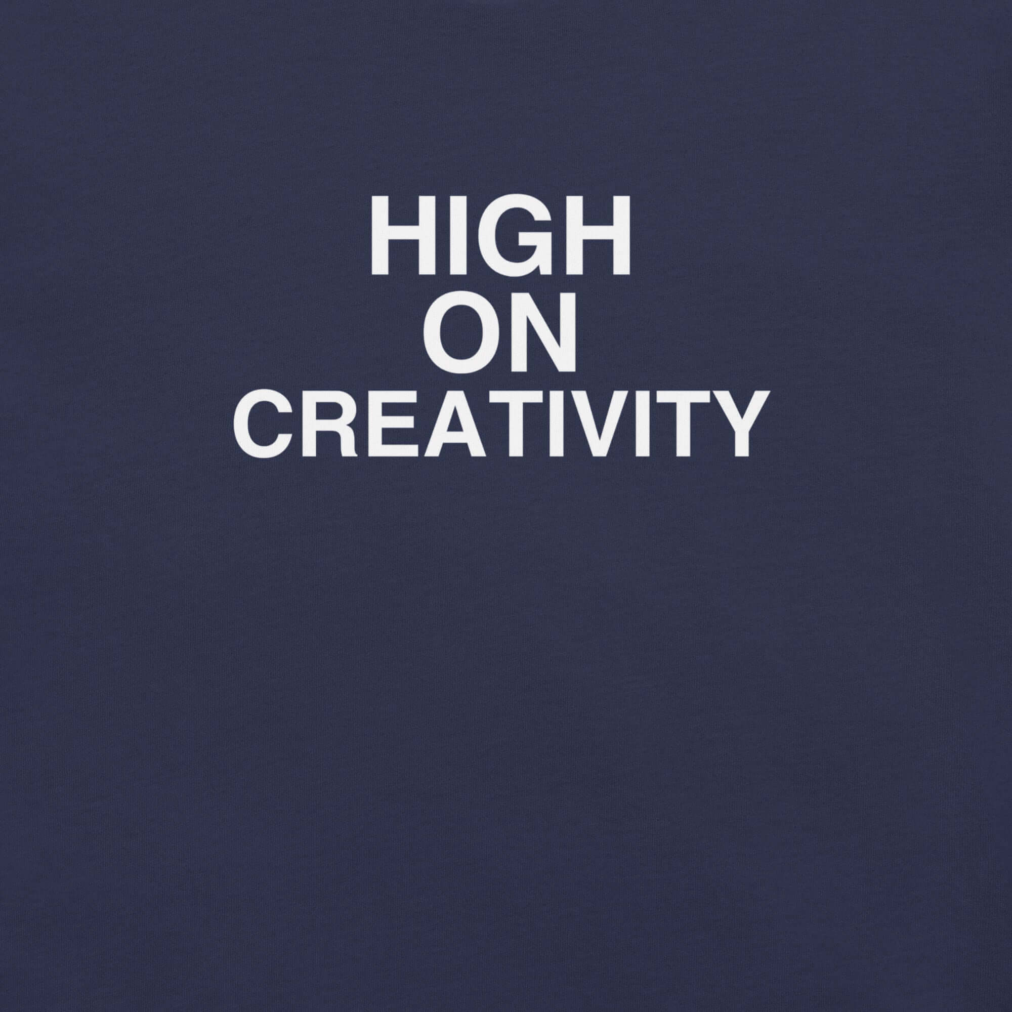Close-up of navy t-shirt fabric with the phrase “HIGH ON CREATIVITY” printed in bold white uppercase letters in three lines.