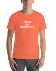 Man wearing a orange t-shirt with the text ‘HIGH ON CREATIVITY’ in bold white capital letters, centered on the chest