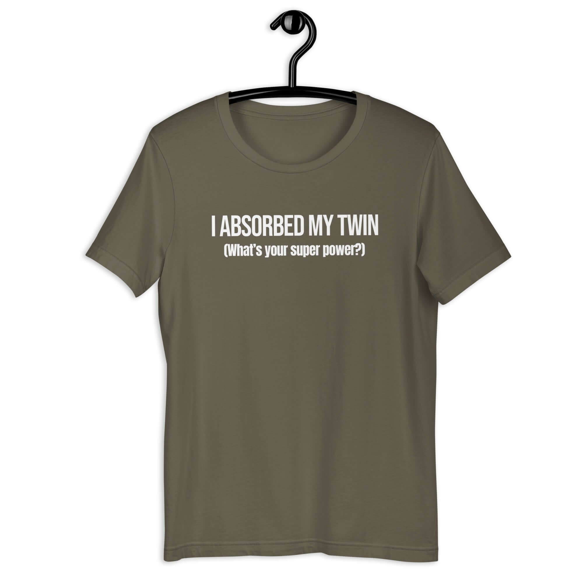 Army t-shirt hanging on a hanger with white text “I ABSORBED MY TWIN (What’s your super power?)” on the front.         