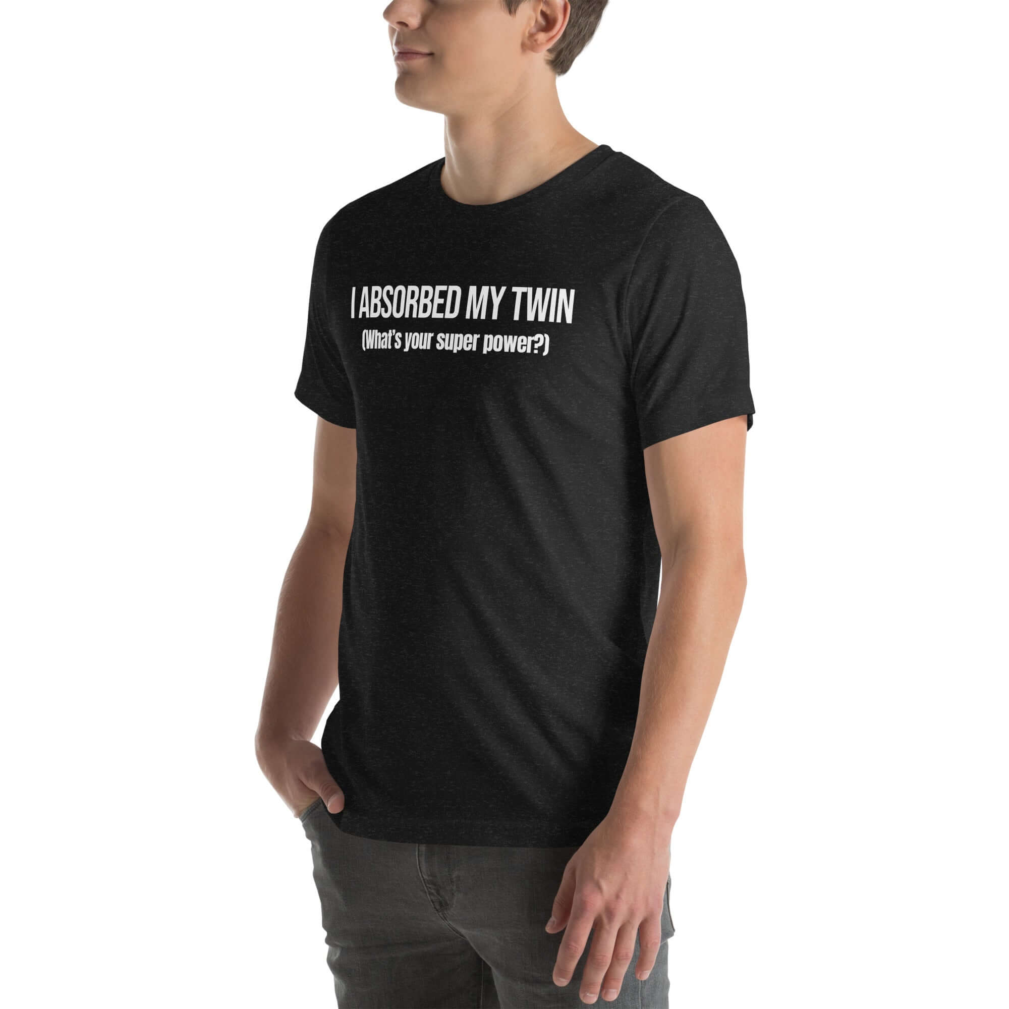 Man wearing black “I ABSORBED MY TWIN (What’s your super power?)” t-shirt, standing sideways with hands in pockets.