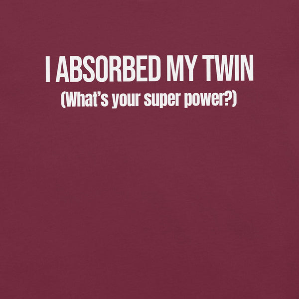 Close-up of maroon t-shirt with white text “I ABSORBED MY TWIN (What’s your super power?)” printed on the front.