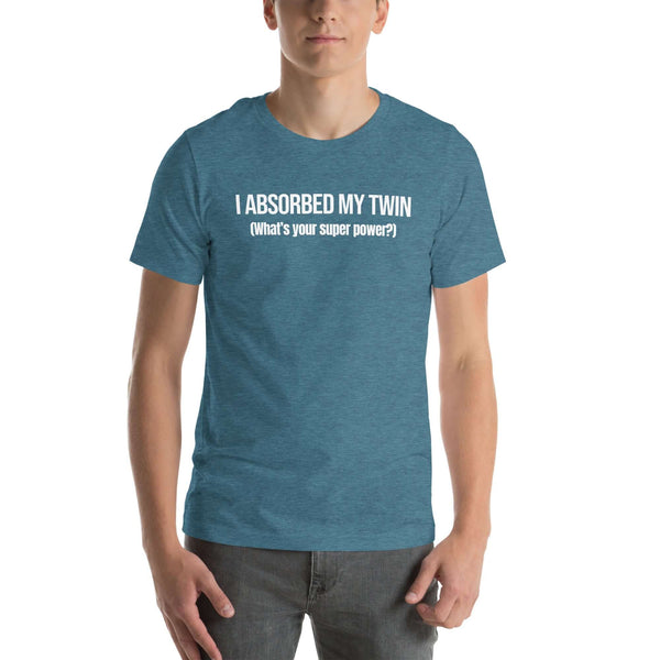 Man wearing teal “I ABSORBED MY TWIN (What’s your super power?)” t-shirt, standing facing forward with hands relaxed.        