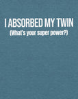 Close-up of teal t-shirt with white text “I ABSORBED MY TWIN (What’s your super power?)” printed on the front.