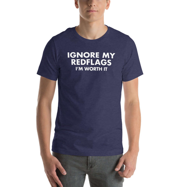 Man wearing navy “IGNORE MY RED FLAGS I’M WORTH IT” t-shirt, standing casually with hands by pockets.