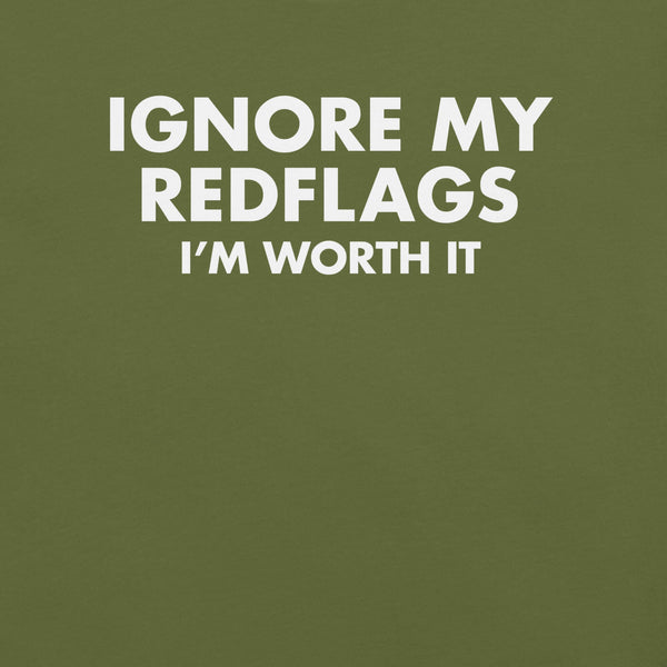 Close-up of olive t-shirt with bold white text “IGNORE MY RED FLAGS I’M WORTH IT” printed on the front.        