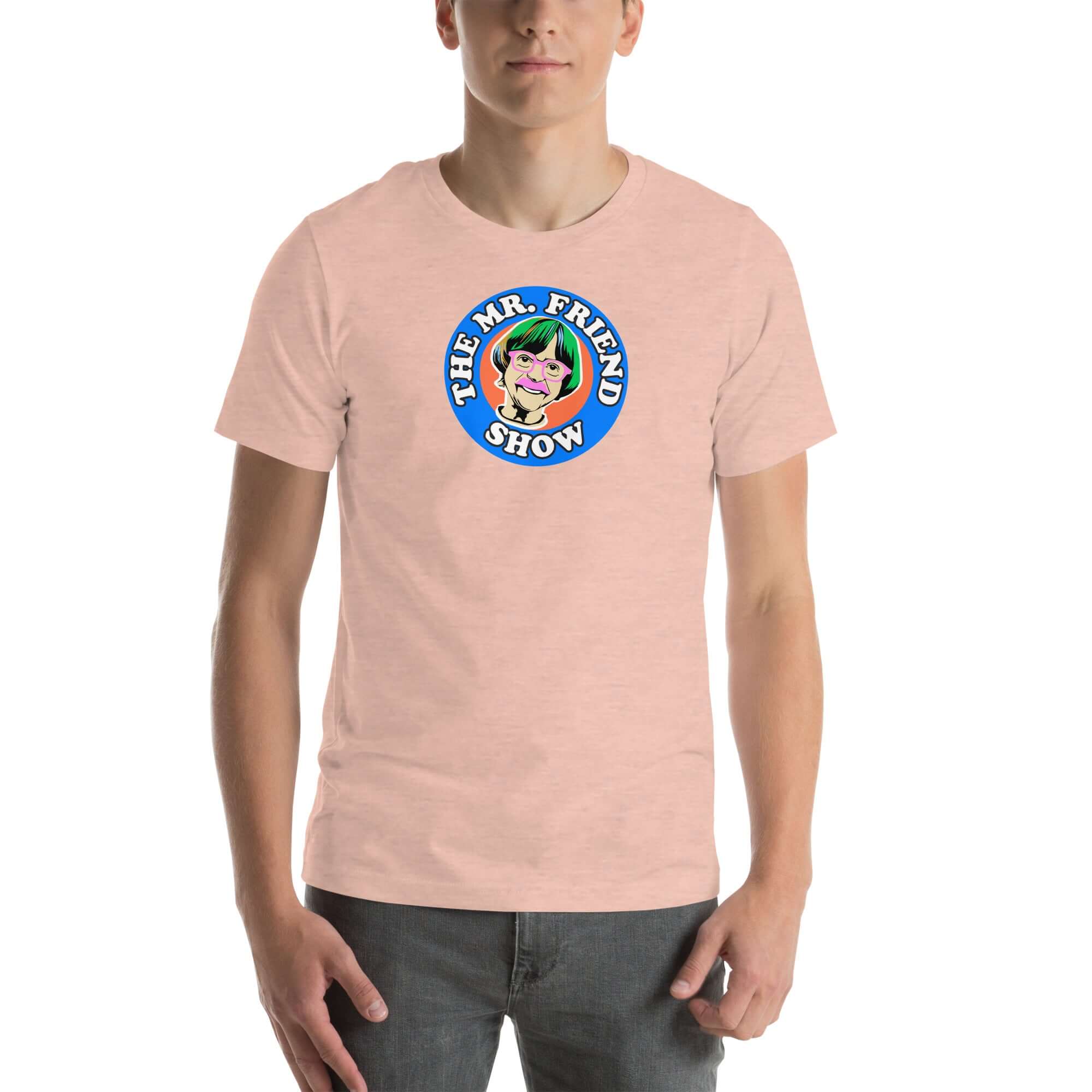 Man wearing a peachy t-shirt featuring 'The Mr. Friend Show' logo with a colorful illustrated portrait and retro-style typography