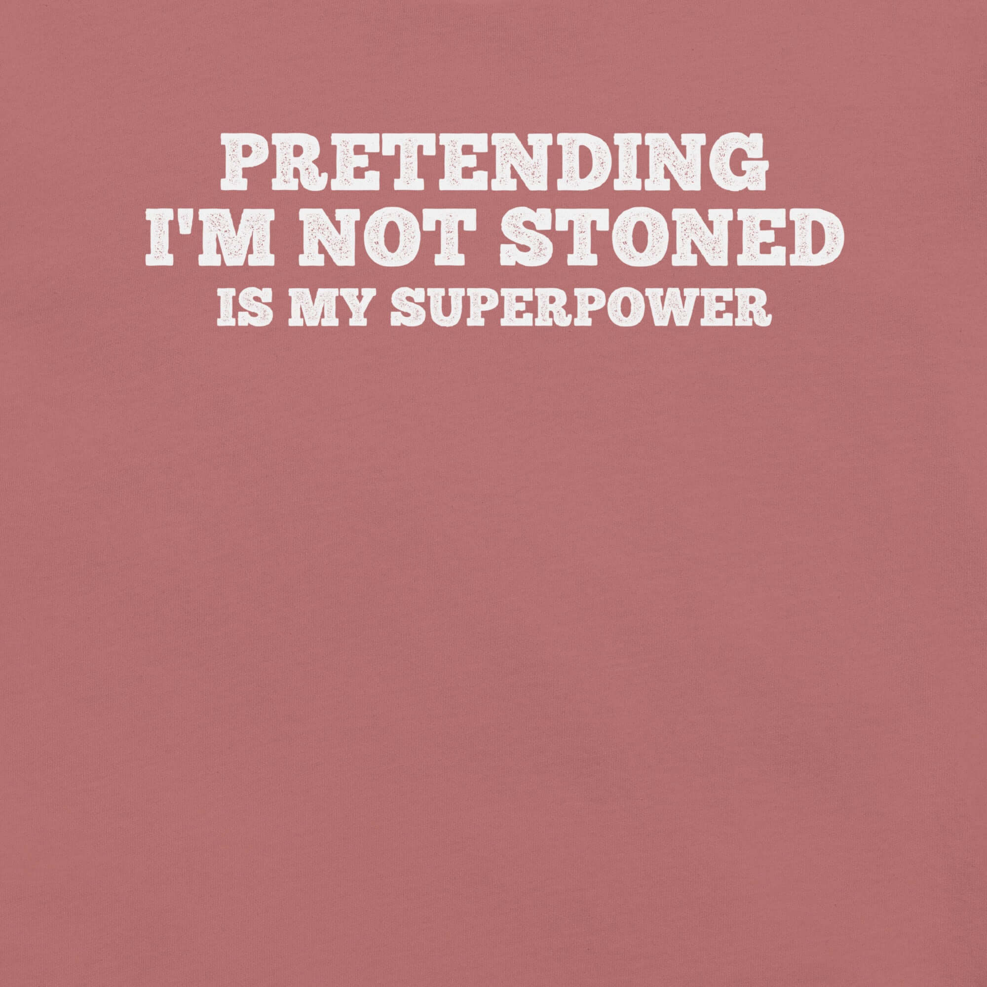 Close-up of mauve t-shirt with white text that says “PRETENDING I’M NOT STONED IS MY SUPERPOWER.”