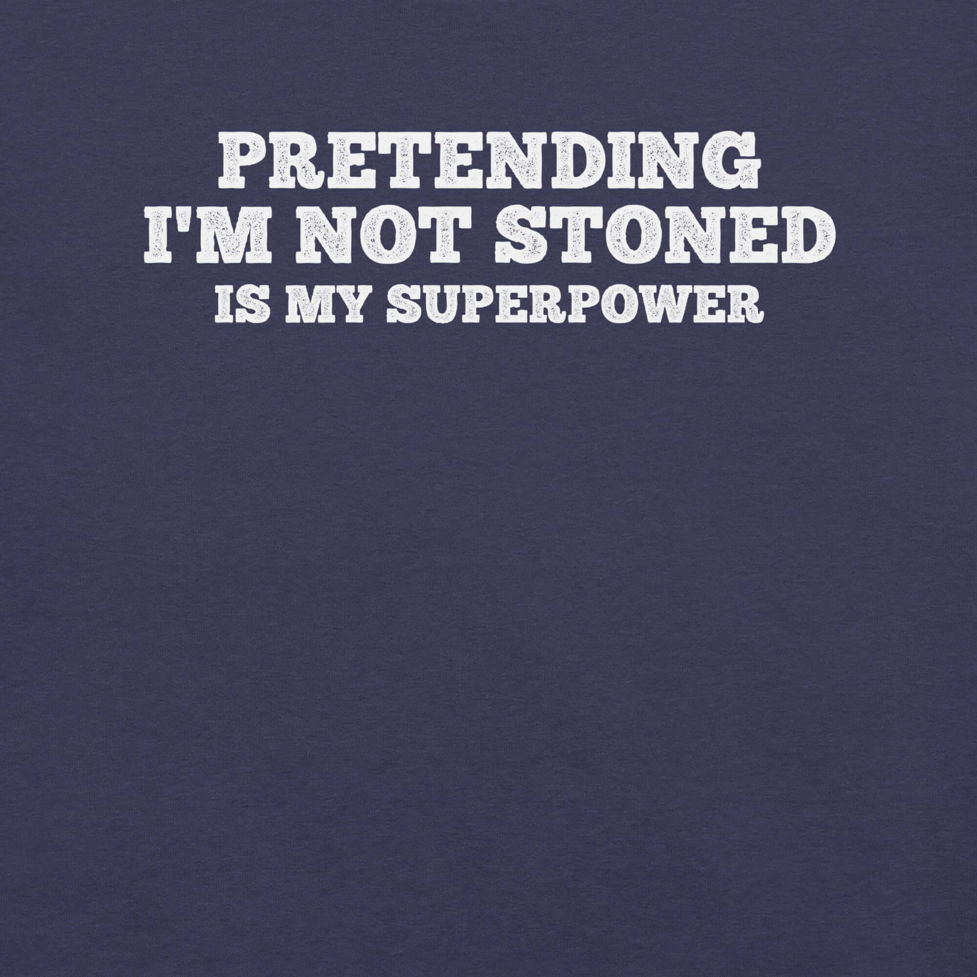 Close-up of navy t-shirt with white text that says “PRETENDING I’M NOT STONED IS MY SUPERPOWER.”