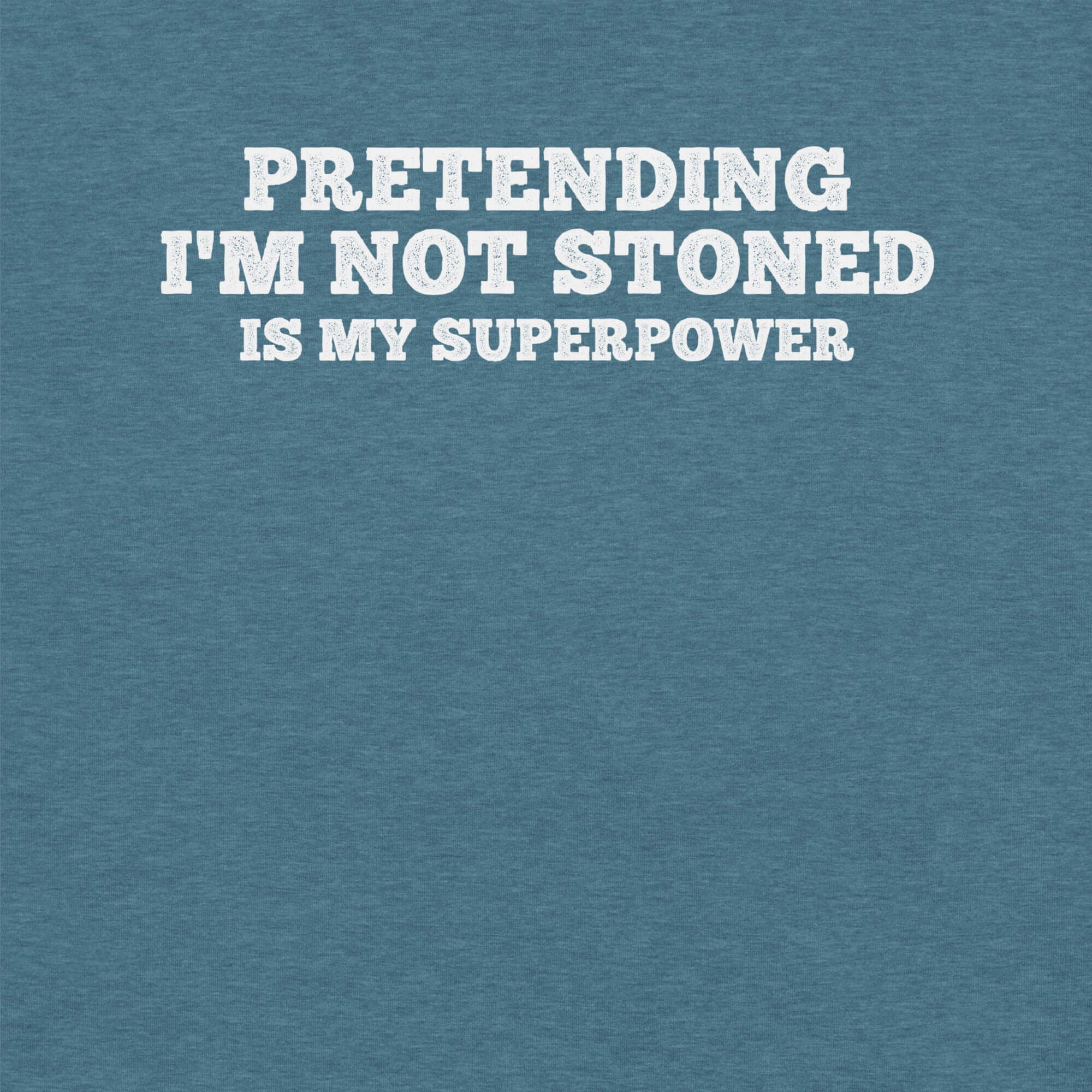 Close-up of teal t-shirt with white text that says “PRETENDING I’M NOT STONED IS MY SUPERPOWER.”