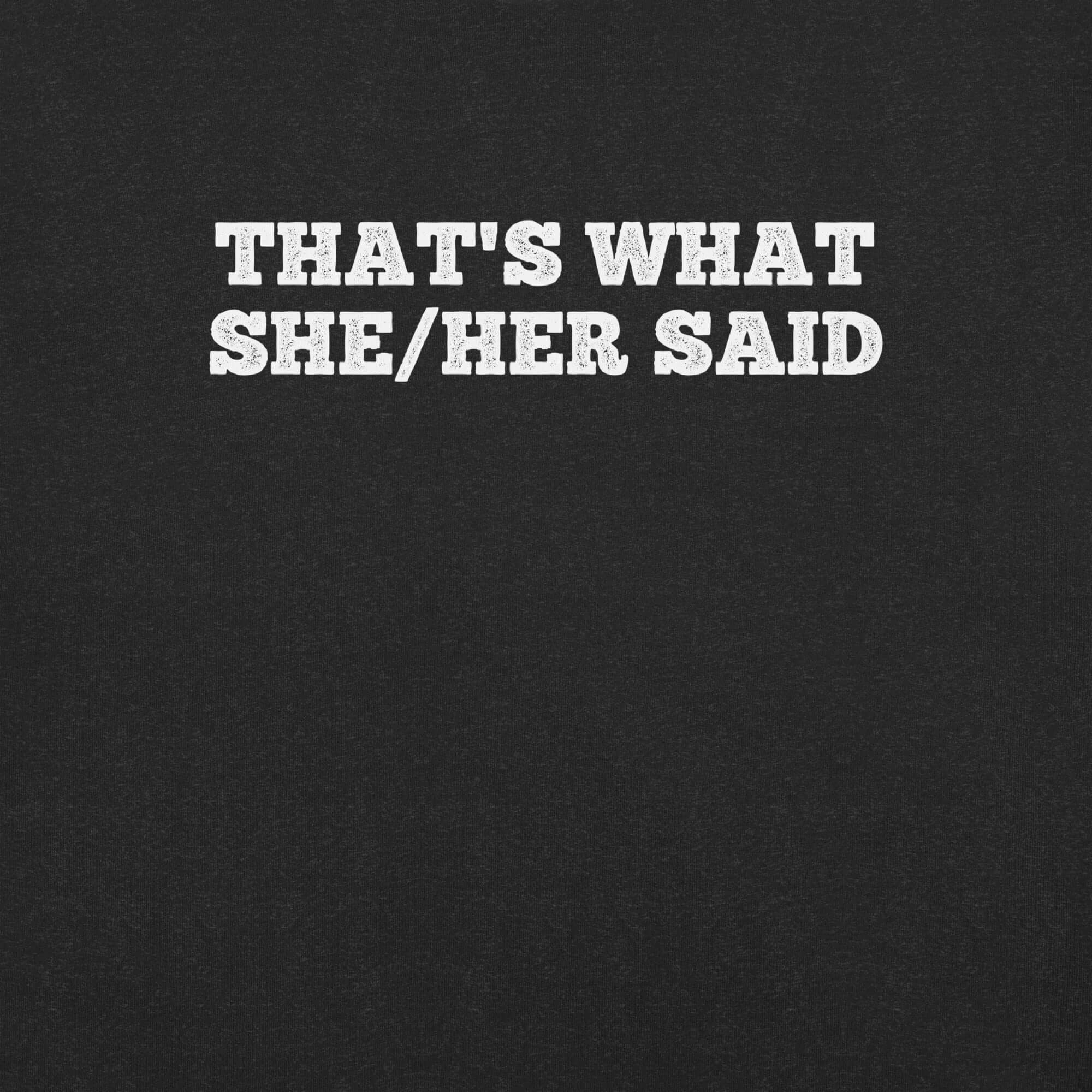Close-up of black t-shirt with bold white text “THAT’S WHAT SHE/HER SAID” across the chest