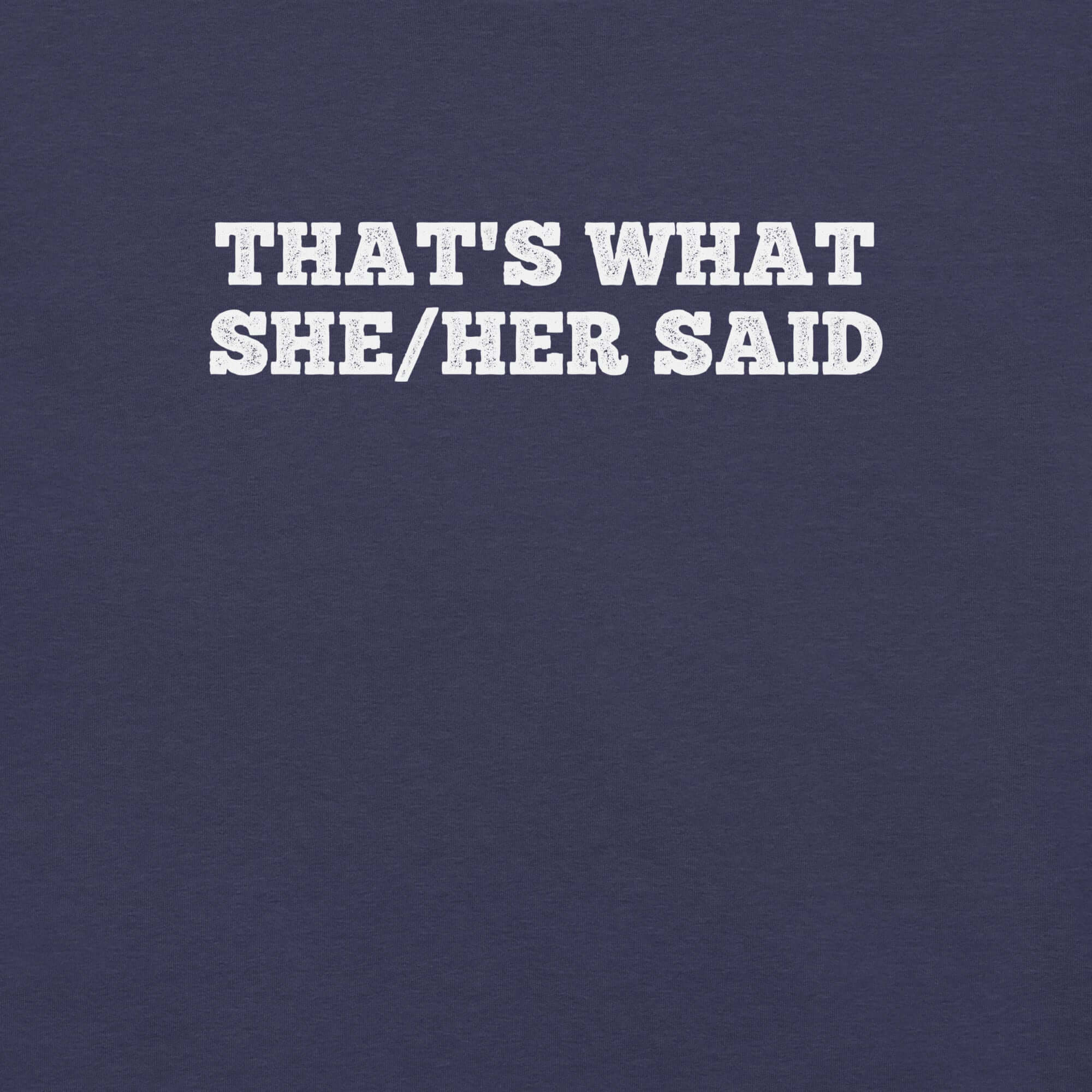Close-up of navy t-shirt with bold white text “THAT’S WHAT SHE/HER SAID” across the chest