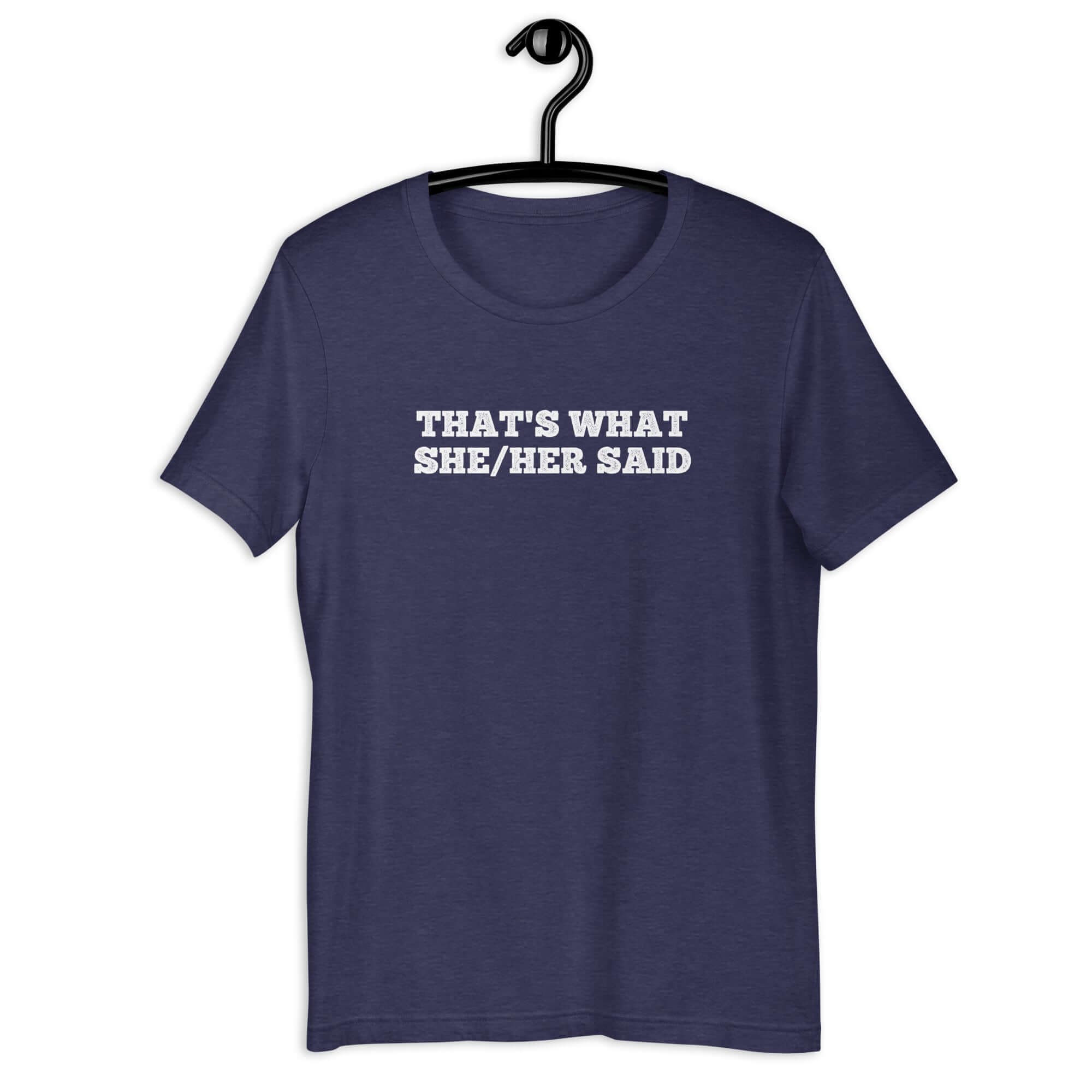 Navy “THAT’S WHAT SHE/HER SAID” t-shirt hanging on a hanger, front design visible.      