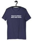 Navy “THAT’S WHAT SHE/HER SAID” t-shirt hanging on a hanger, front design visible.      