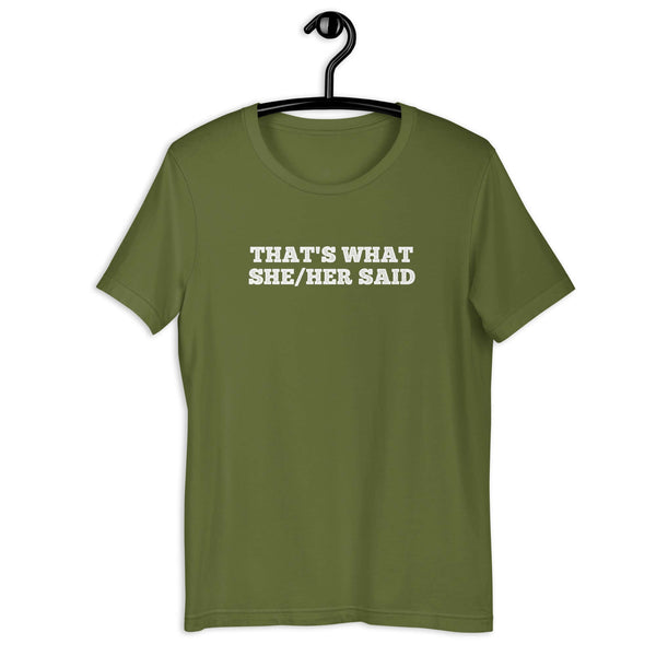 Olive “THAT’S WHAT SHE/HER SAID” t-shirt hanging on a hanger, front design visible.      