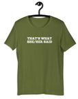 Olive “THAT’S WHAT SHE/HER SAID” t-shirt hanging on a hanger, front design visible.      