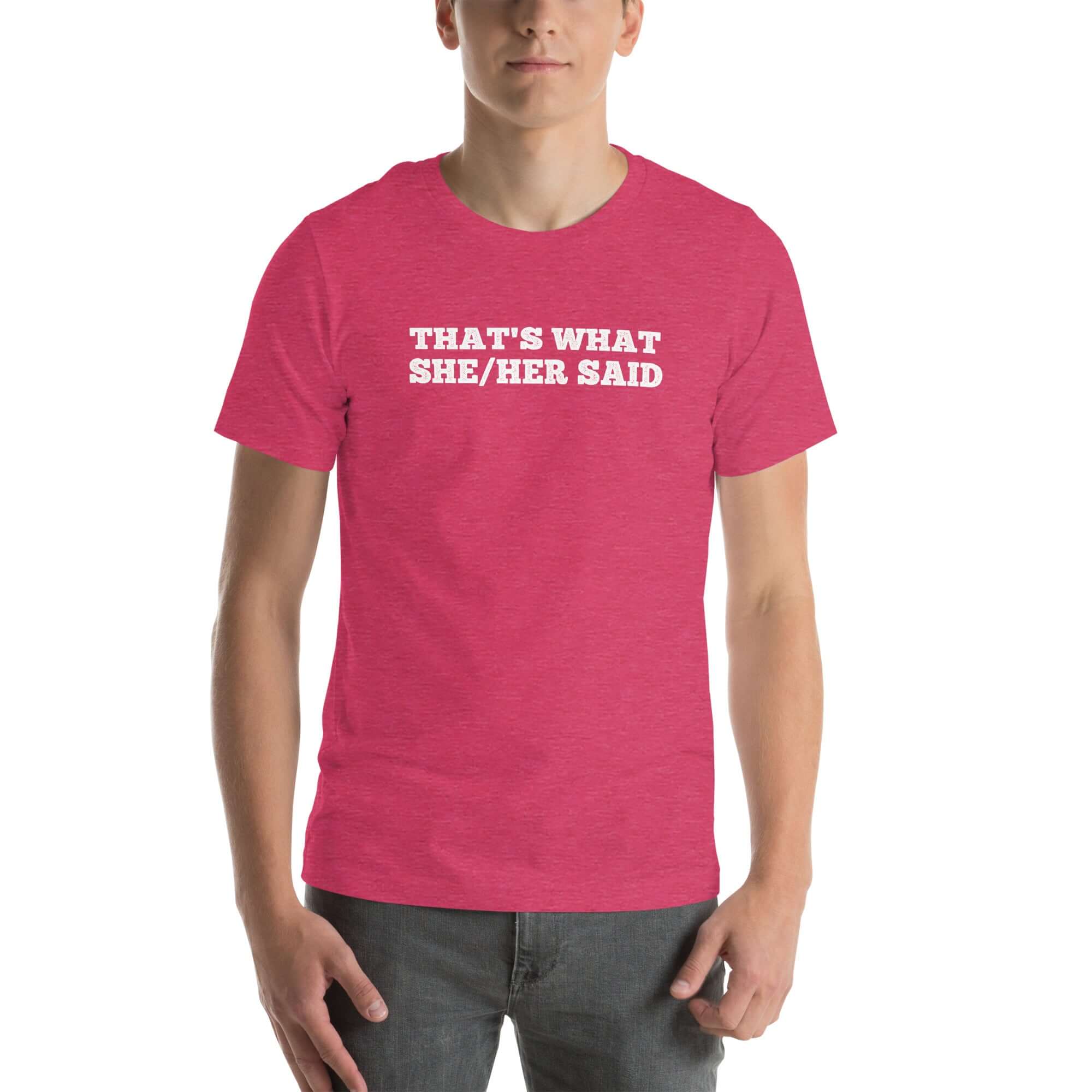 Man wearing pink “THAT’S WHAT SHE/HER SAID” t-shirt, hands in pockets, looking relaxed to the front