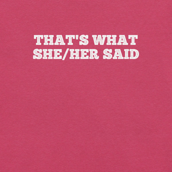 Close-up of pink t-shirt with bold white text “THAT’S WHAT SHE/HER SAID” across the chest