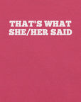 Close-up of pink t-shirt with bold white text “THAT’S WHAT SHE/HER SAID” across the chest