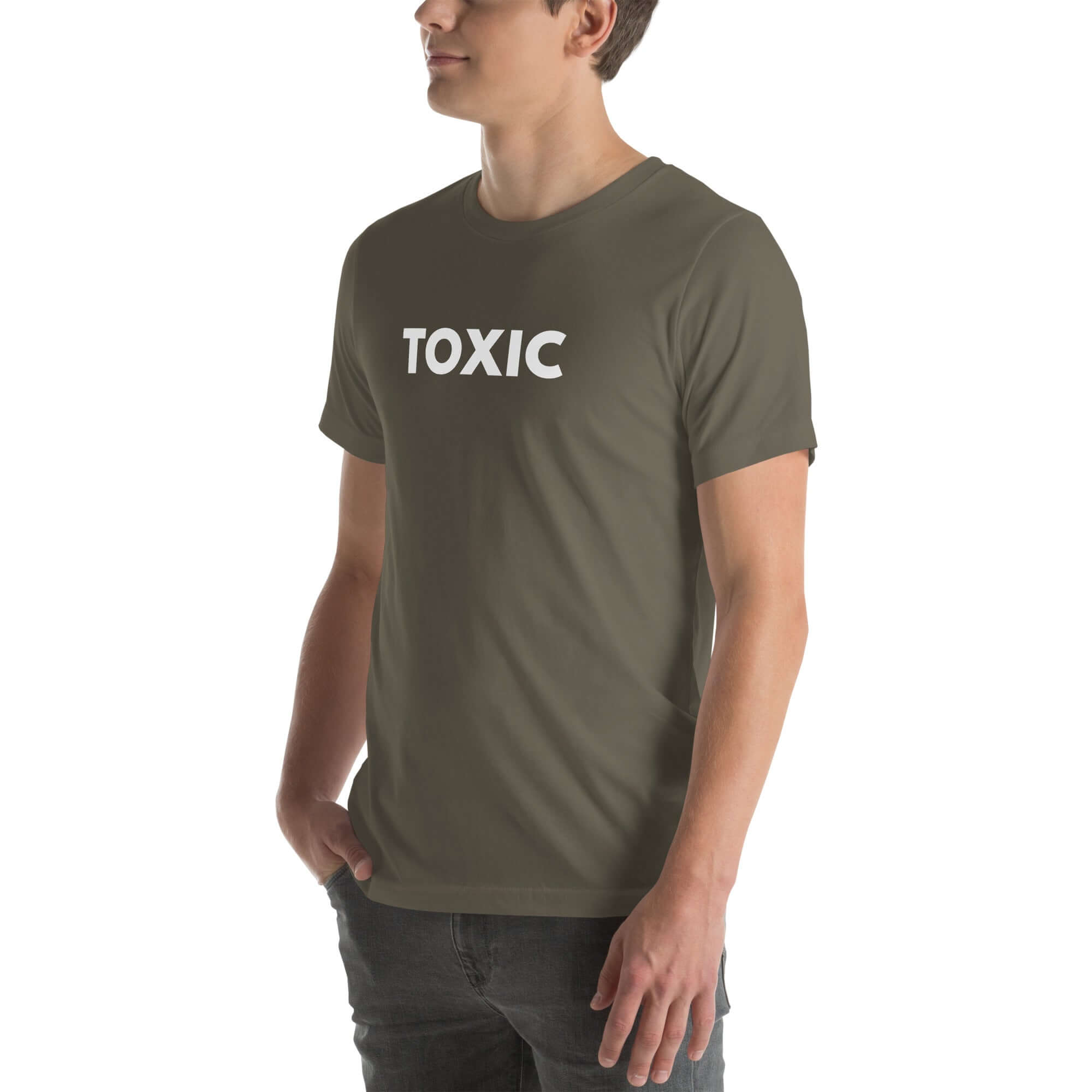Man wearing army “TOXIC” t-shirt, standing sideways with hands in pockets, looking off to the side.