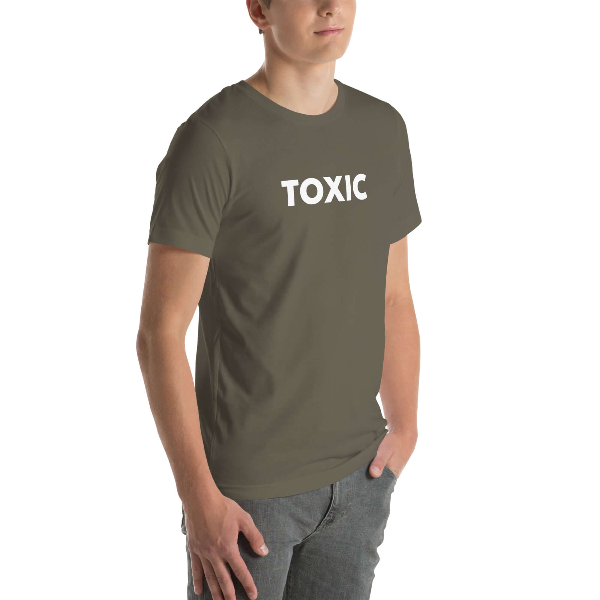 Man wearing army “TOXIC” t-shirt, standing with hands in pockets, looking slightly to the side.