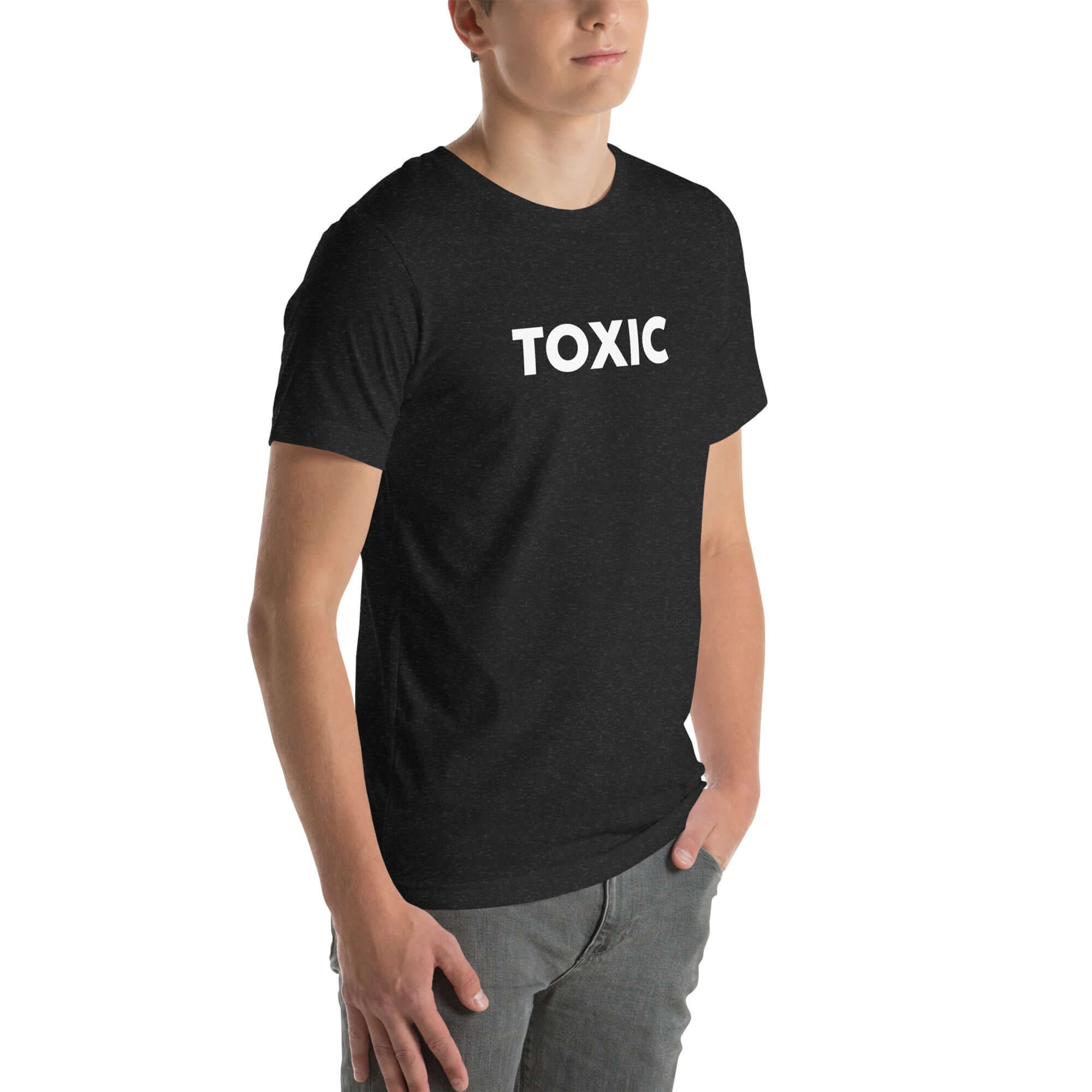 Man wearing black “TOXIC” t-shirt, standing with hands in pockets, looking slightly to the side.