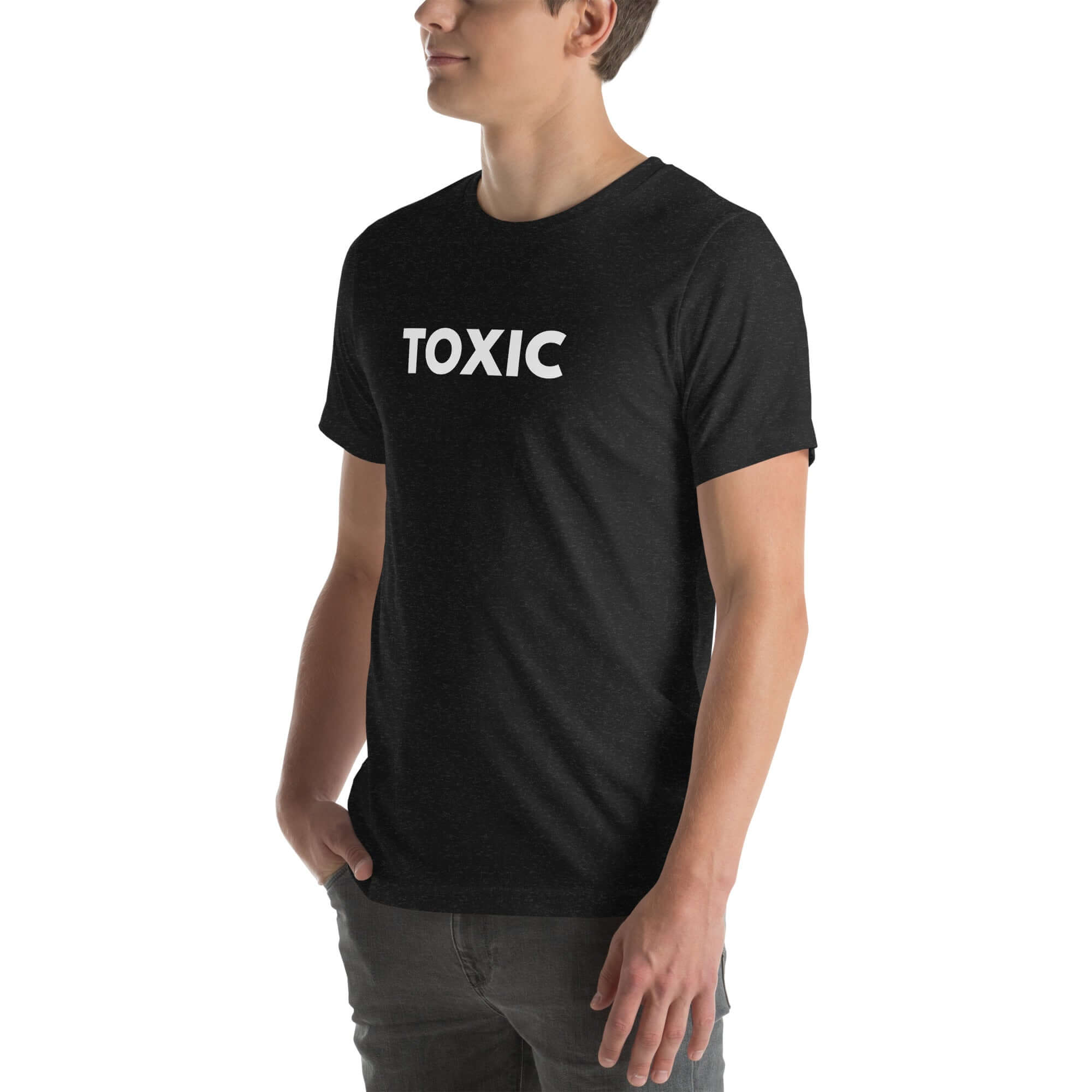 Man wearing black “TOXIC” t-shirt, standing sideways with hands in pockets, looking off to the side.