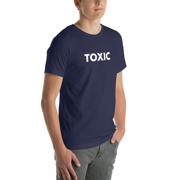 Man wearing navy “TOXIC” t-shirt, standing with hands in pockets, looking slightly to the side.