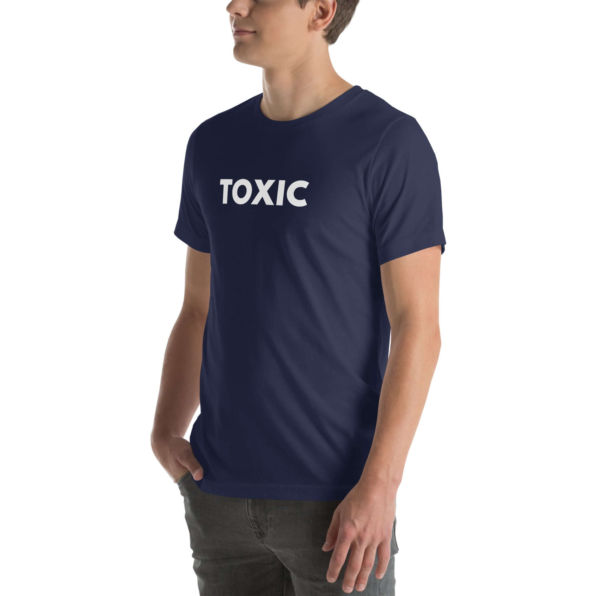 Man wearing navy “TOXIC” t-shirt, standing sideways with hands in pockets, looking off to the side.
