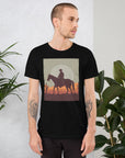 Unisex black t-shirt featuring cowboy silhouette design against desert sunset background, perfect for casual style.