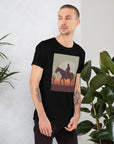 Unisex black t-shirt featuring cowboy silhouette design against a sunset backdrop, perfect for casual wear.