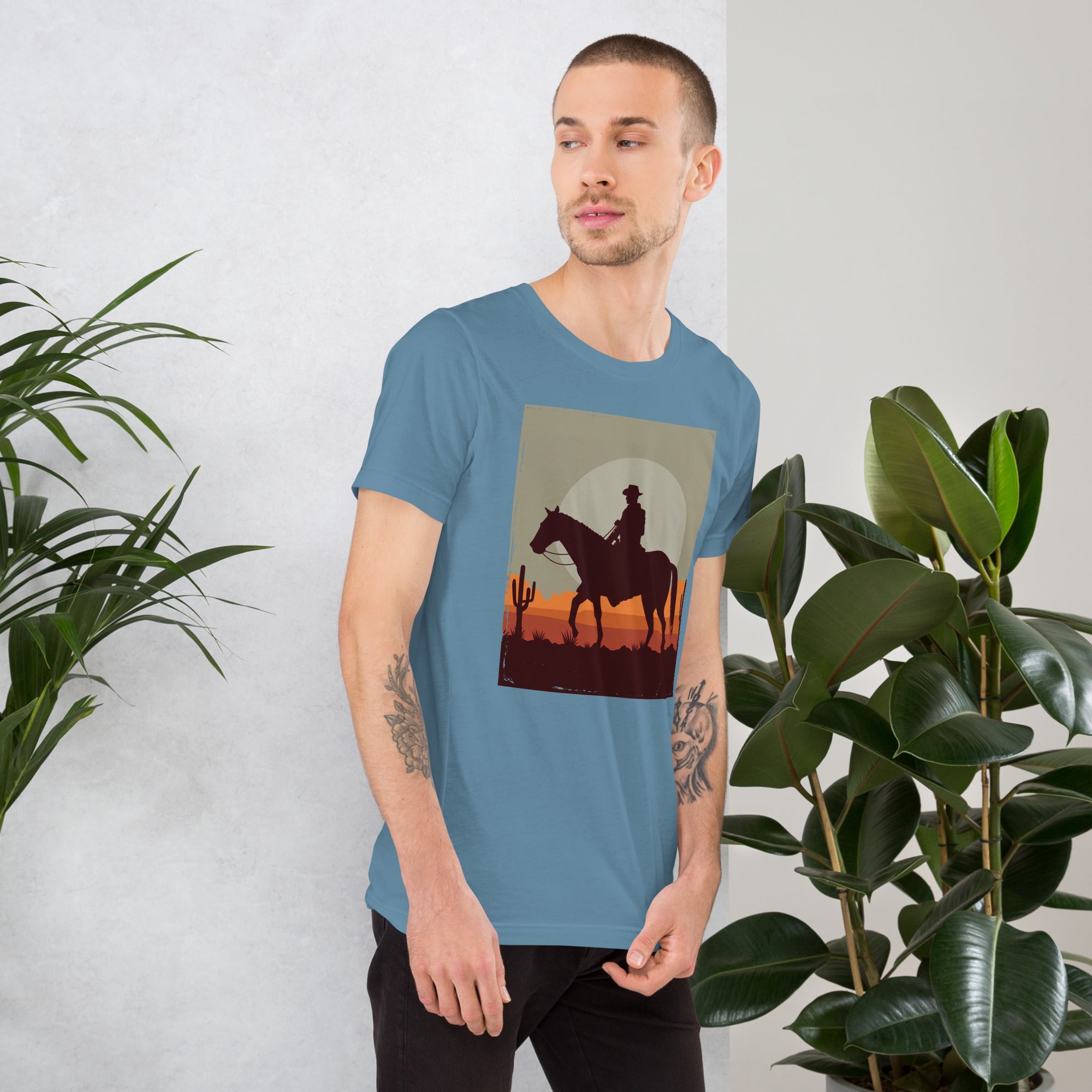 Unisex t-shirt featuring a silhouetted cowboy riding a horse against a sunset backdrop, perfect for casual wear.